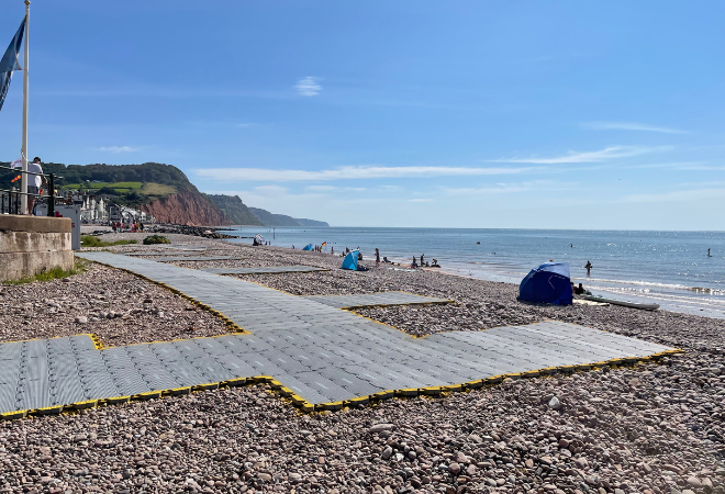 "Image of Sidmouth beach with tiles placed on the gravel to aid visitors onto the beach"