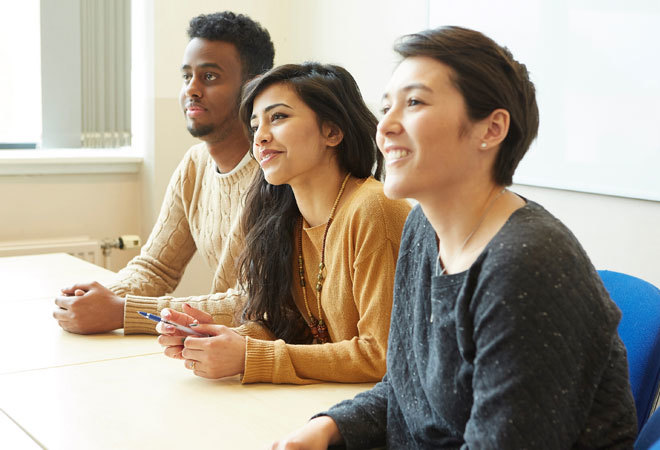 Three students sat at a table in a lesson.