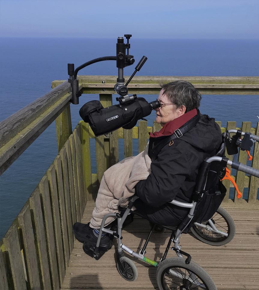 "person looking through a viewing scope"