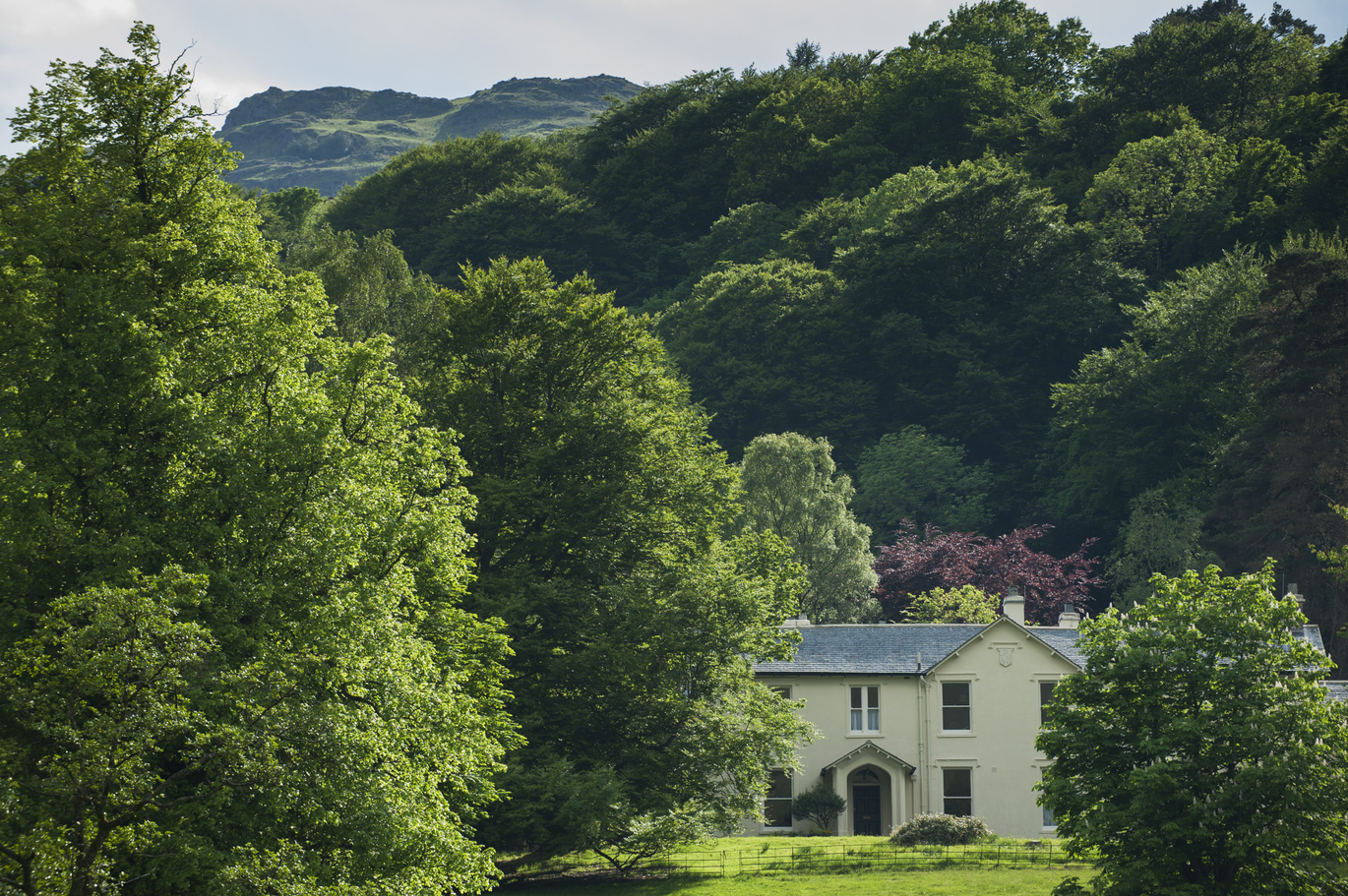 View of the house and grounds at Allan Bank, Grasmere, Cumbria, surrounded by woodland.