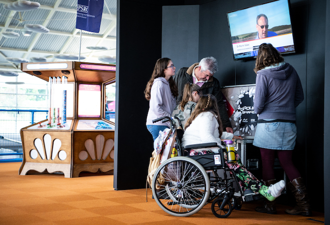 "Photo of a group of people looking at a screen inside the centre."