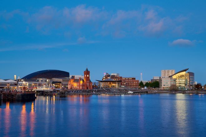 "Cardiff Bay at dusk, taken from over the water, looking at the shore"