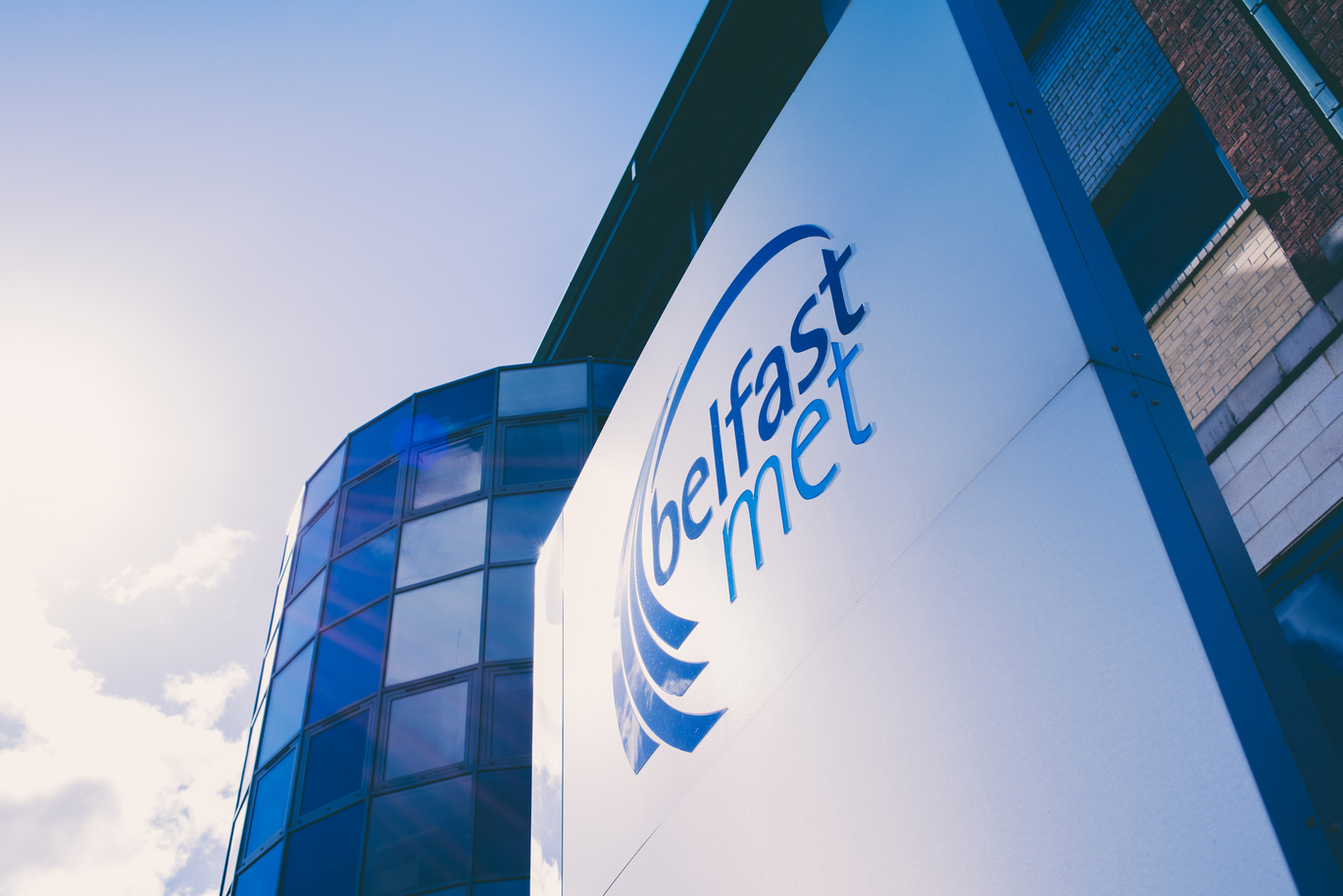 "Exterior shot of Millfield Campus with sign reading Belfast Met"