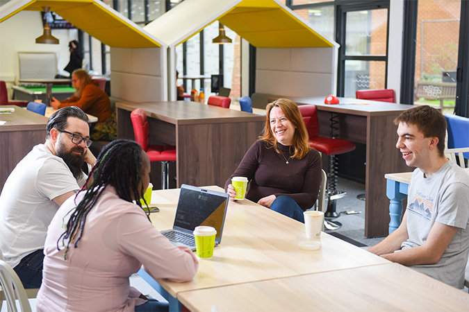 "photo of a group of people in discussion whilst study"