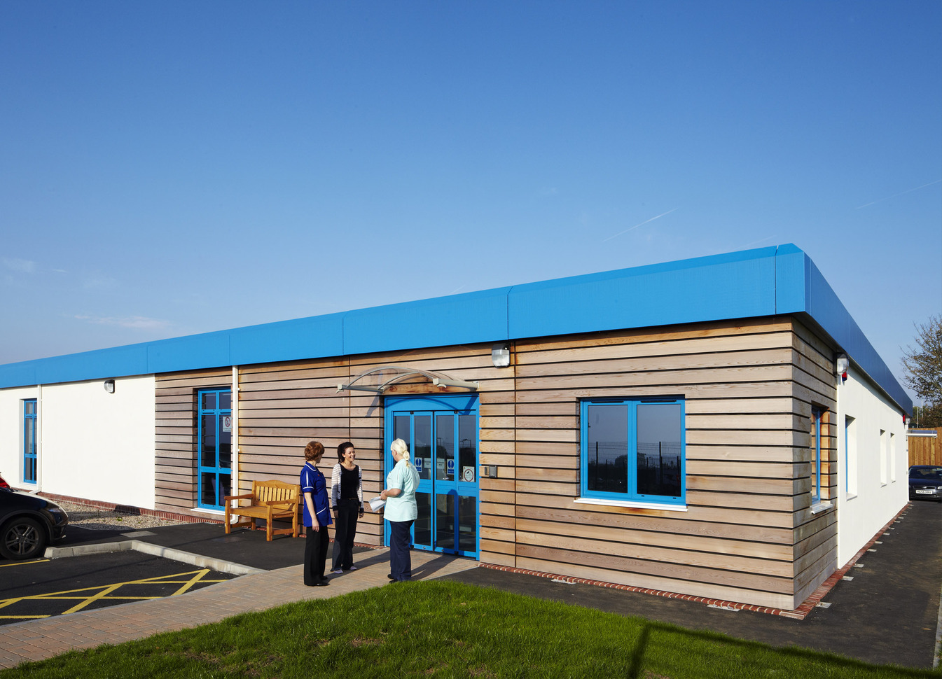 single story building made from wood with white sides and a blue roof.