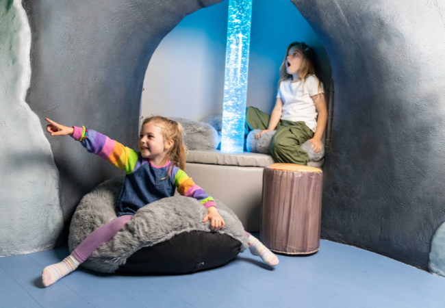 children sitting on a cushion and seat  