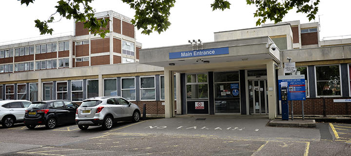 The entrance has a large 'Main Entrance' signage above, and car parking is shown in front of the building