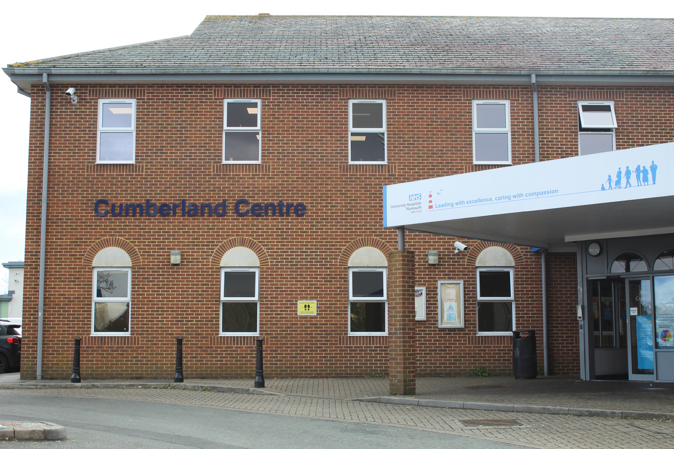 brick building with white horning to the left