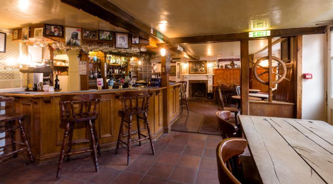 "Internal view of Lord Nelson pub showing a table and the bar in the distance"