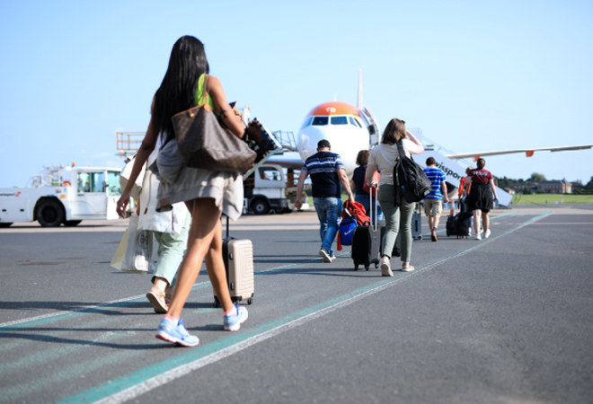 "Photograph of a number of passengers walking toward an aircraft to board"