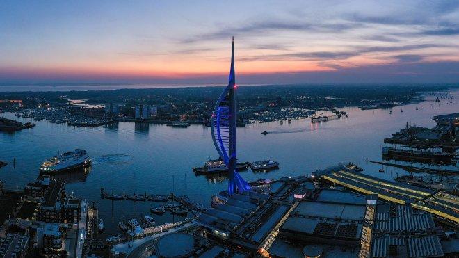 "Evening aerial view of Gunwharf Quays with Spinnaker Tower beside the waterfront at sunset."