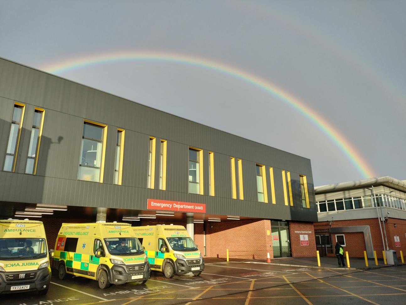 "Emergency Department with ambulances outside with a rainbow over the building"