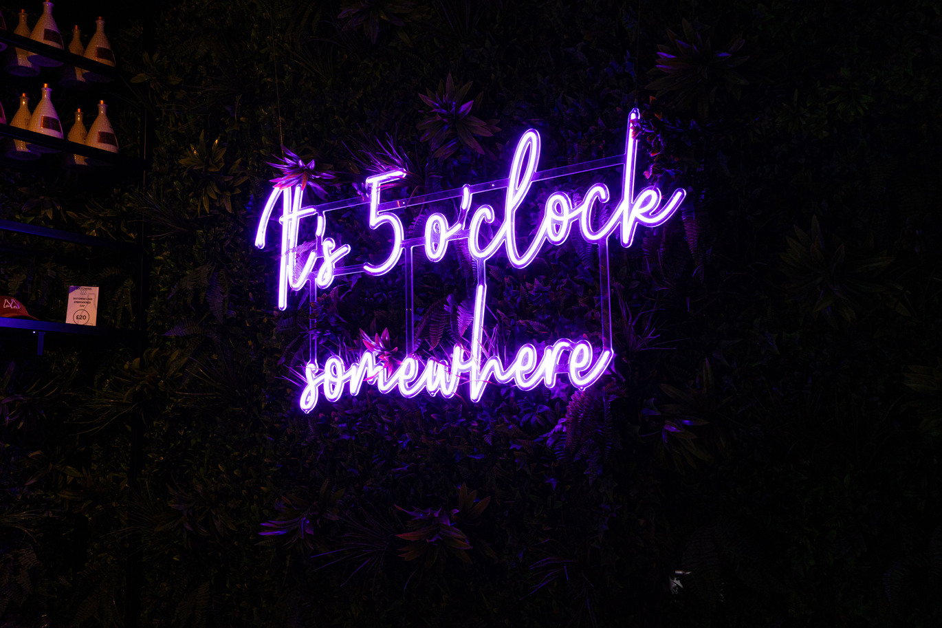 ''neon light saying it's five o'clock somewhere''