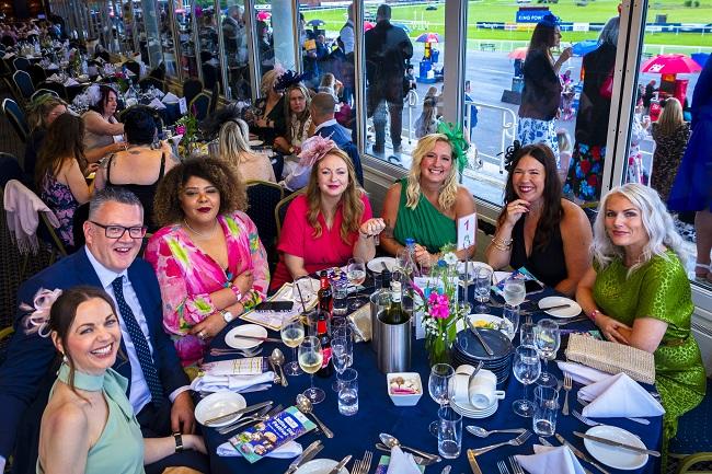 "A group of people enjoying a meal in hospitality during Ladies Day"