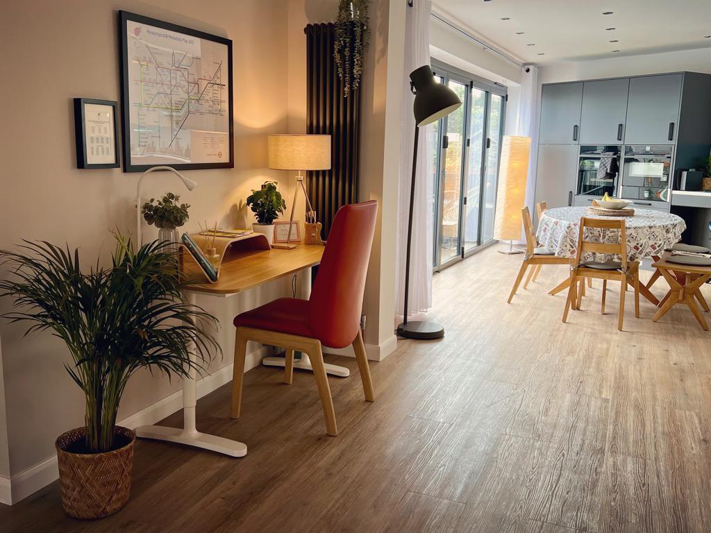 'chair and desk facing the wall with kitchen diner in the background'