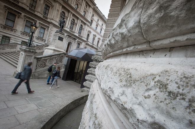 Photo showing entrance to Churchill War Rooms with steps the left, the entrance in the middle and a stone pillar to the right.
