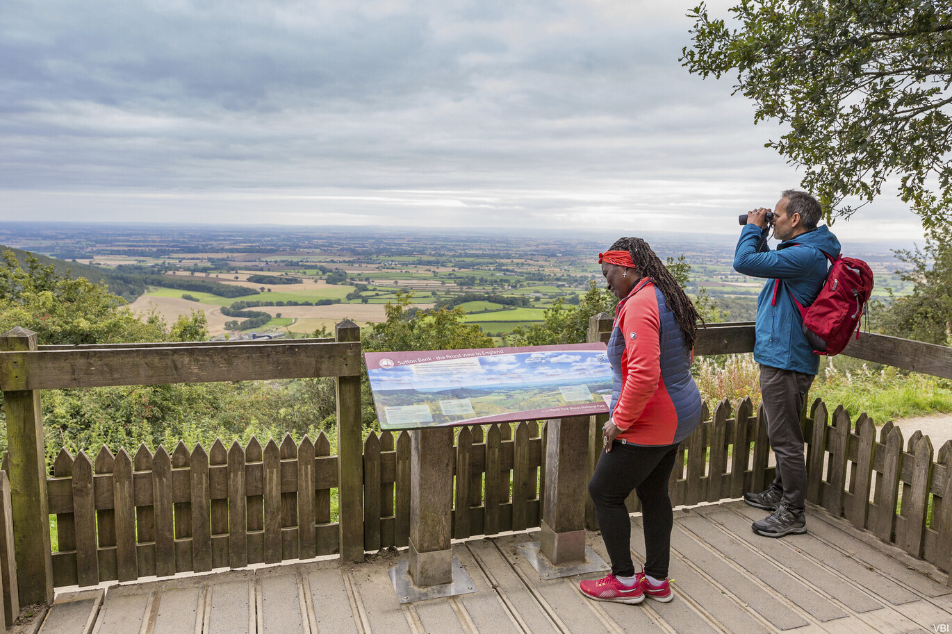 "Two people stood outside looking over Sutton Bank"