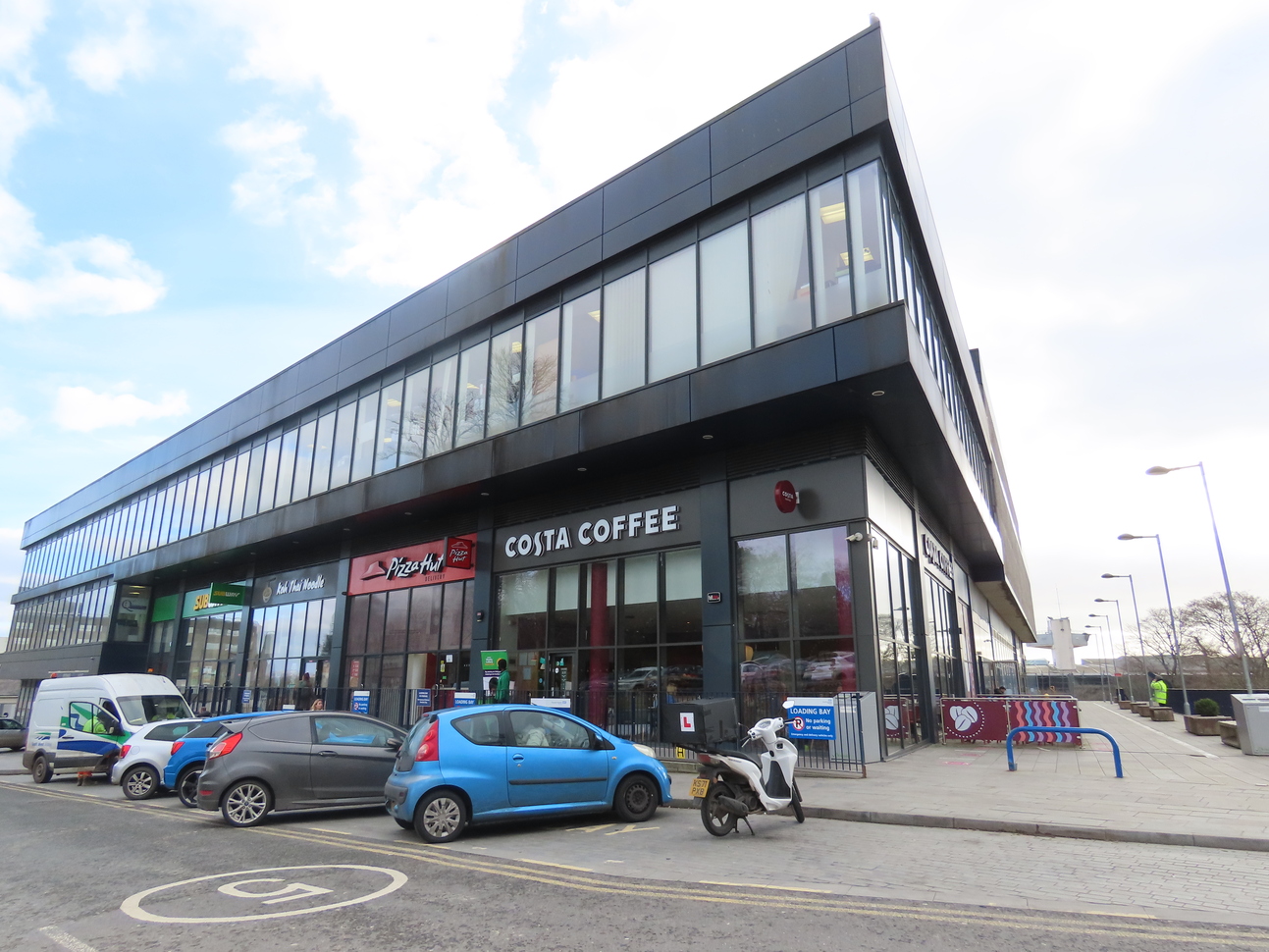 Grey building with shops and cars