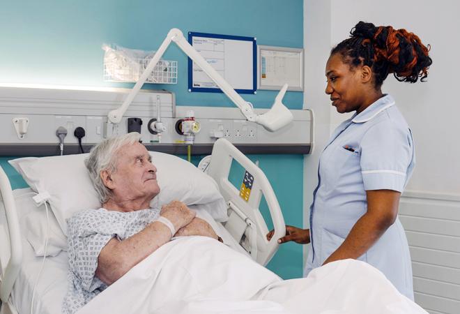 "A nurse caring for a patient in bed"