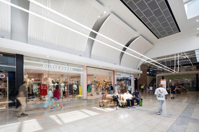 "Indoor shopping centre walkway with Oliver Bonas store, seating area and people walking."