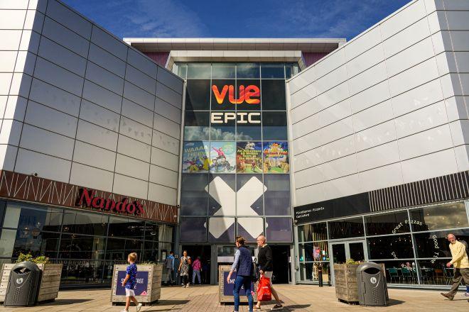 "Entrance to Vue cinema at Xscape with large “Vue EPIC” sign, glass façade, and people walking outside."