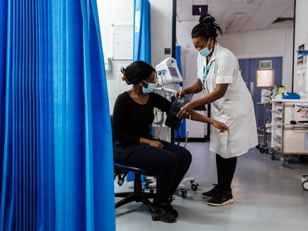"patient having their blood pressure checked on their arm"
