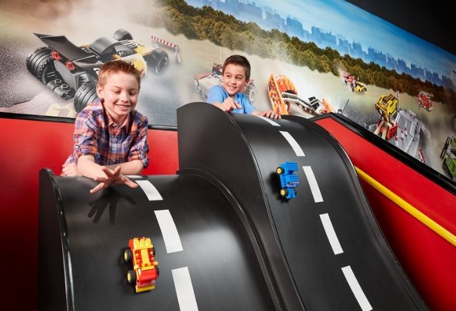 "two kids playing with cars"