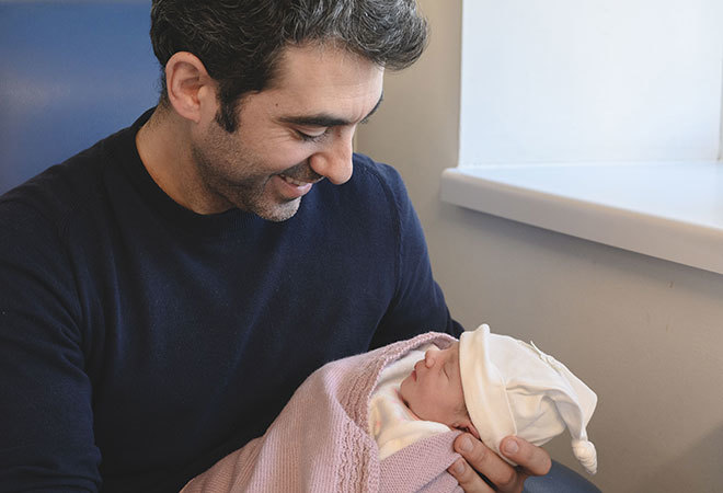 "Father holding newborn baby"