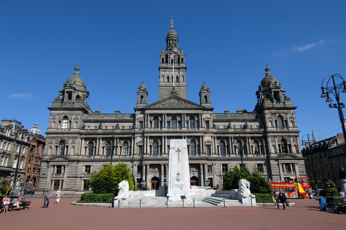 "Glasgow City Hall building and monument in George Square against clear blue skies"