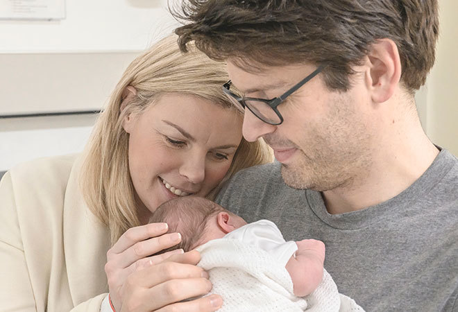"Couple holding newborn baby"