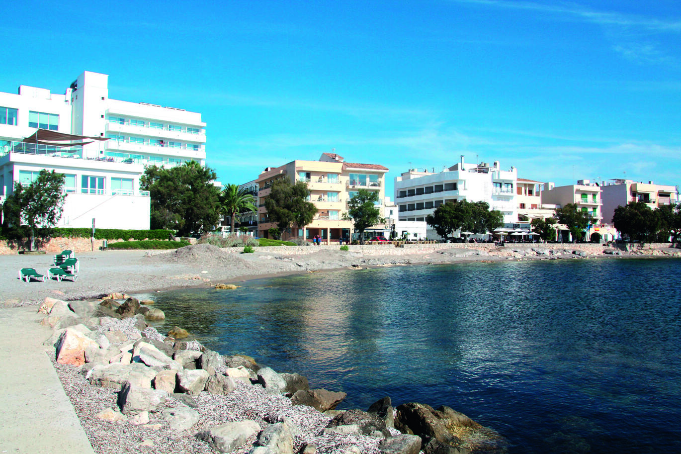 A view from the beach with the sea to the right of a few different hotel complexes behind.