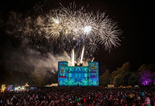 "Camp Bestival at night with fireworks above main stage at Lulworth Castle"