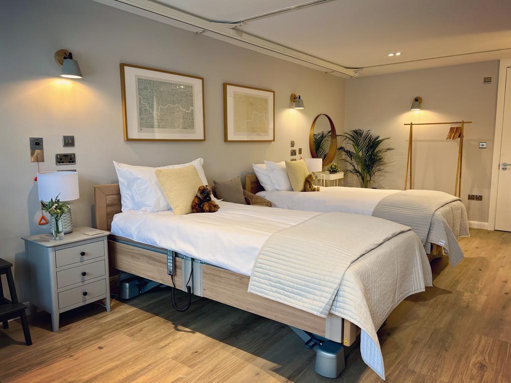 'two beds side by side with art on the wall above'