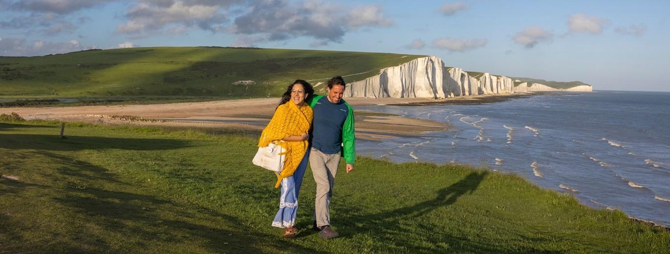 "Two people standing in front of the cliffs at Seven Sisters"
