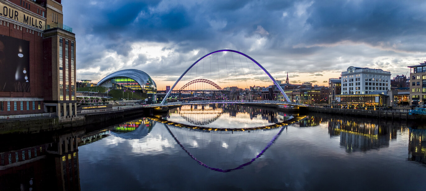 "The Quayside and Newcastle Bridge with sun setting in distance"