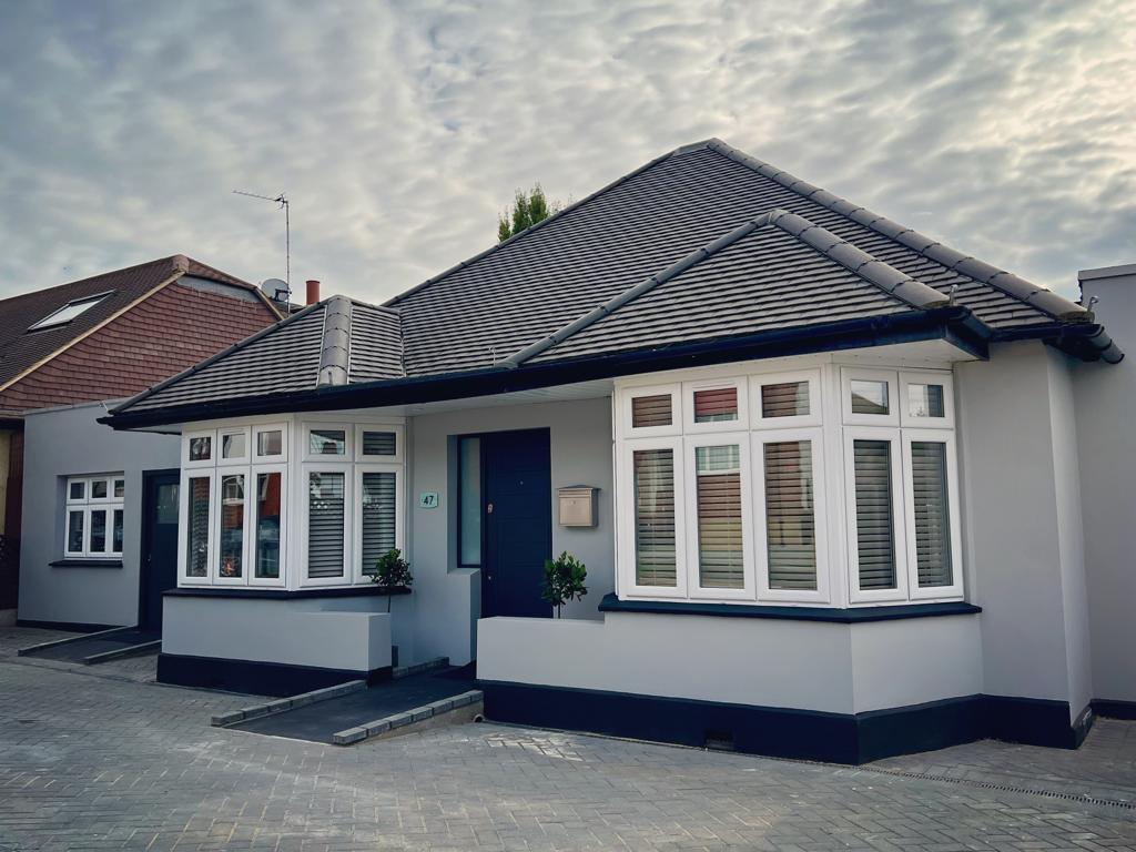 ''front of building with ramp leading up to a blue front door''