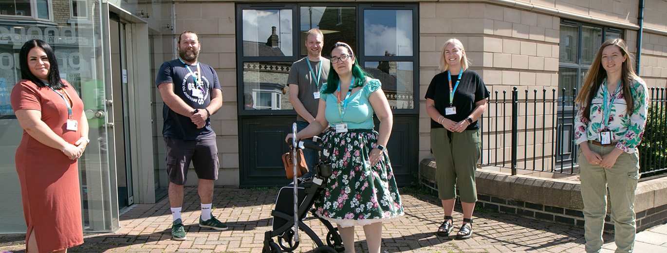 "Photo of 5 Beyond Housing staff members standing outside the entrance to their office"