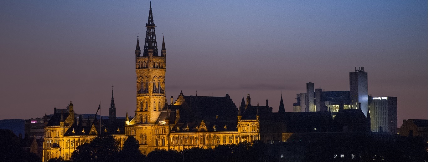 "University of Glasgow building at night against city skyline"