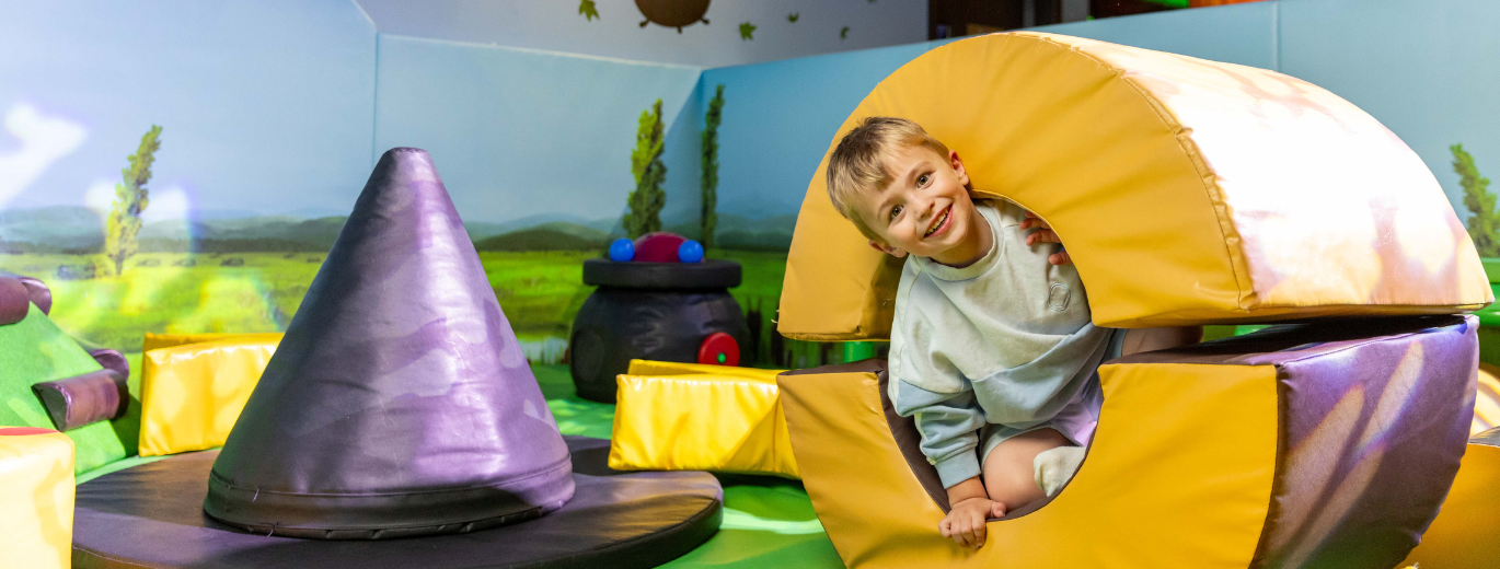 child playing in a cylinder soft play 