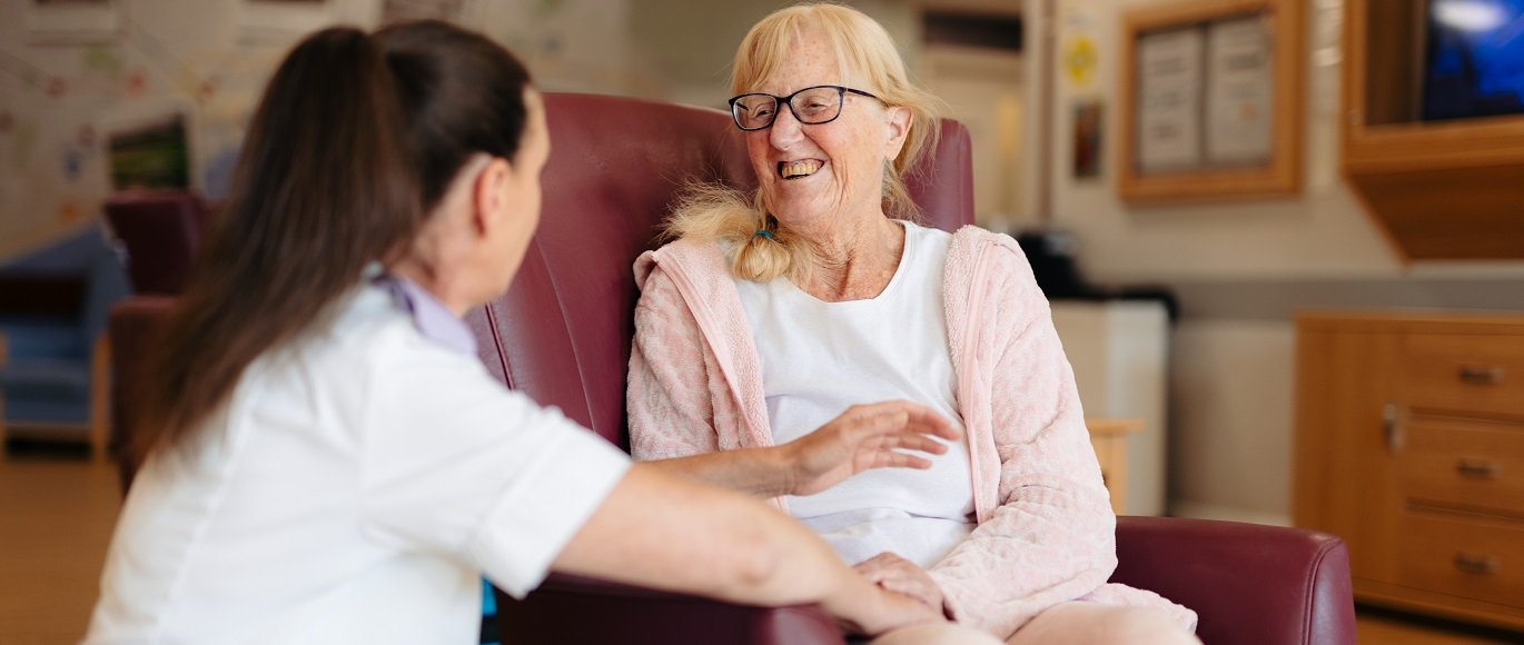 Female nurse engaging with elderly patient, its all smiles