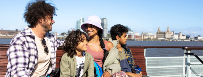 A family sat on a boat in the sunshine on the mersey 