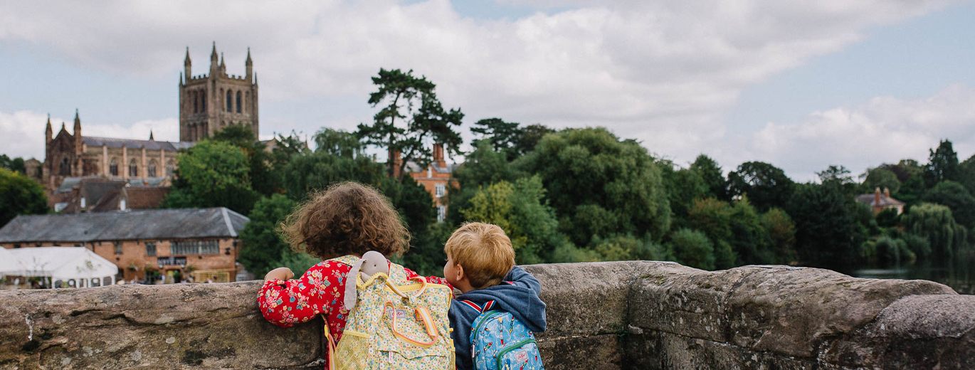 Two Children peer over a wall at Hereford's Vista 