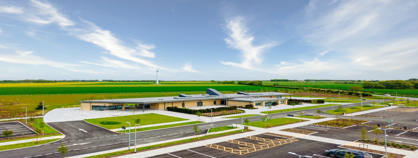 "Ariel view of the crematorium with a backdrop of green fields and blue sky"