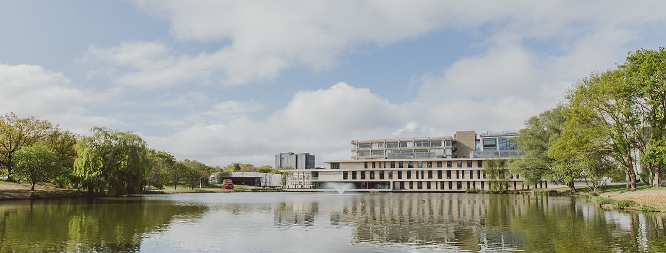 "Colchester Campus. Large lake in foreground, library building in background."