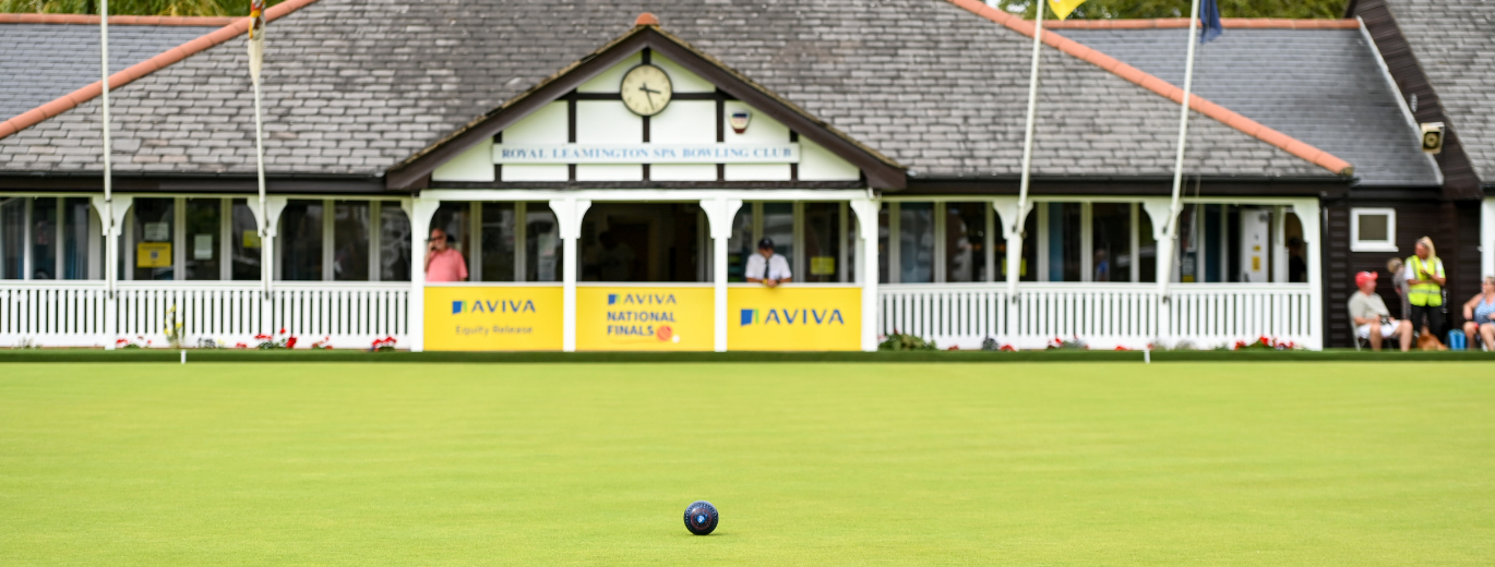 A loan bowl on the green, pavilion in the background