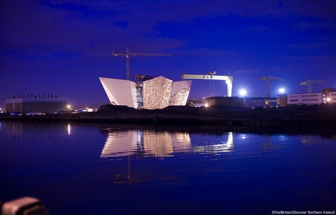The Titanic memorial in Belfast harbour, lit up against the night sky.