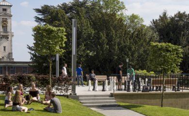 Students on grass outside a university building
