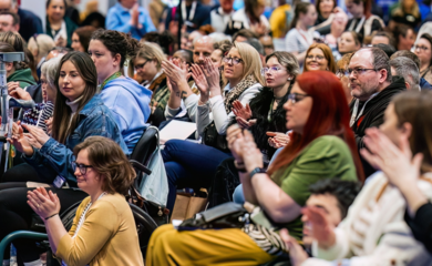 A photo of a diverse audience group applauding.
