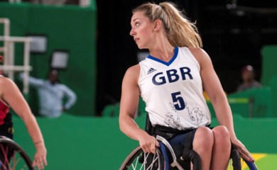 Sophie in her sports wheelchair on a basketball court