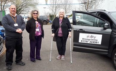 3 people stood next to a car